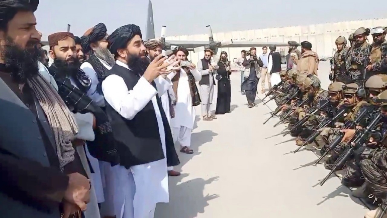 Juru bicara Taliban Zabihullah Mujahid dan pasukan Badri 313 di bandara Kabul. (Reuters)