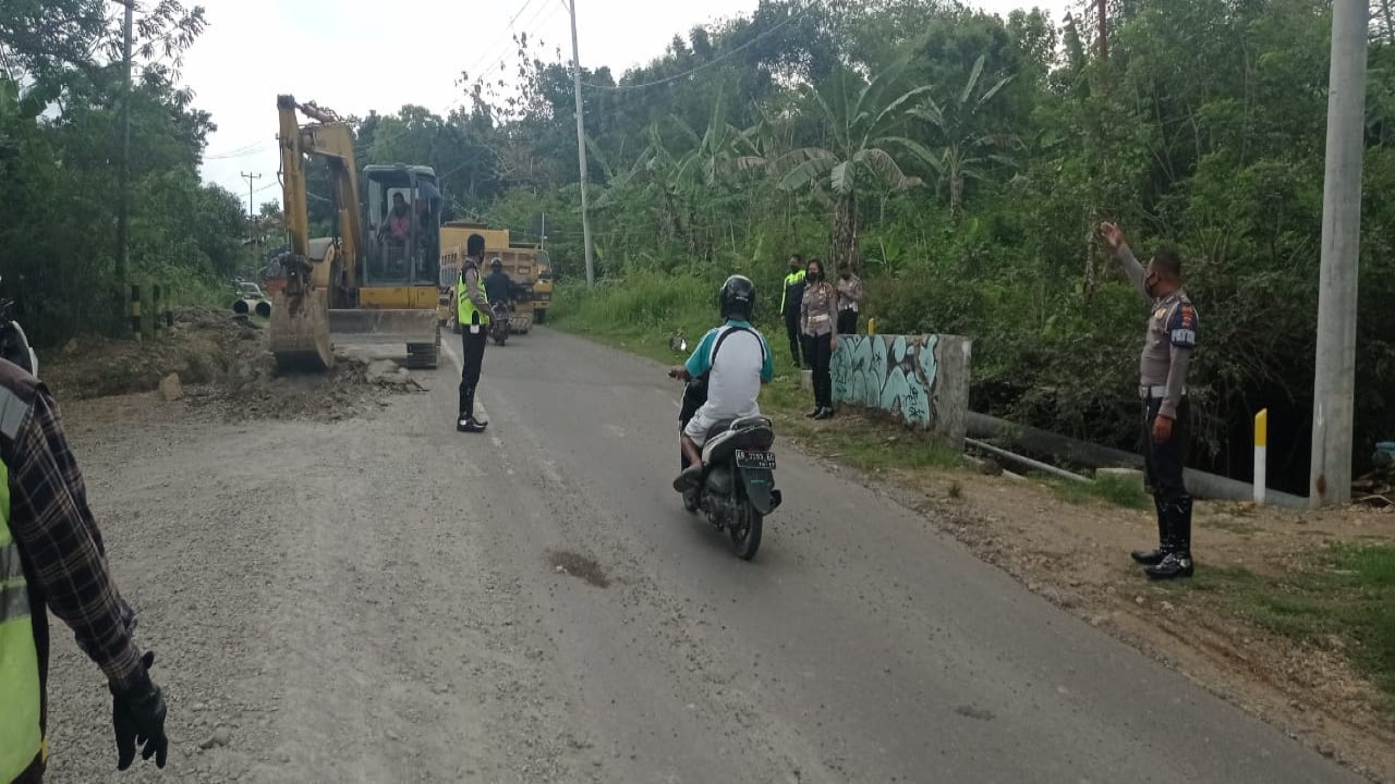 Satuan Lantas Polres Manggarai Barat saat membersihkan tumpahan material proyek di jalan Trans Flores.