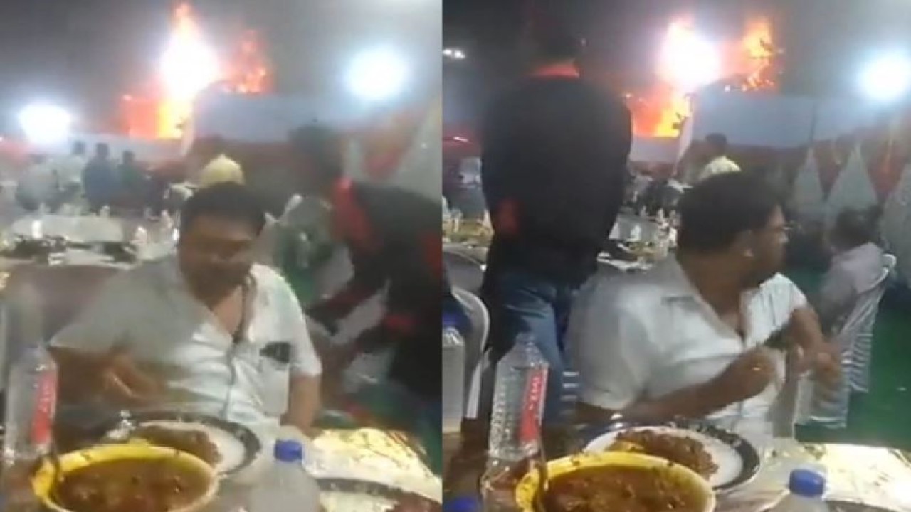 Seorang pria tetap asyik menikmati makanan meski dibelakang terjadi kebakaran. (World of Buzz)