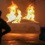 Demonstran membakar kendaraan yang diduga mobil polisi dalam kerusuhan di Kazakhstan-1641537556