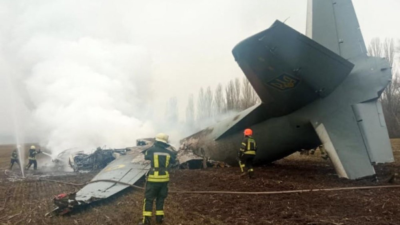 Personel dinas darurat bekerja di lokasi jatuhnya pesawat militer Ukraina di selatan Kiev pada Kamis (24/2/2022). (AFP)