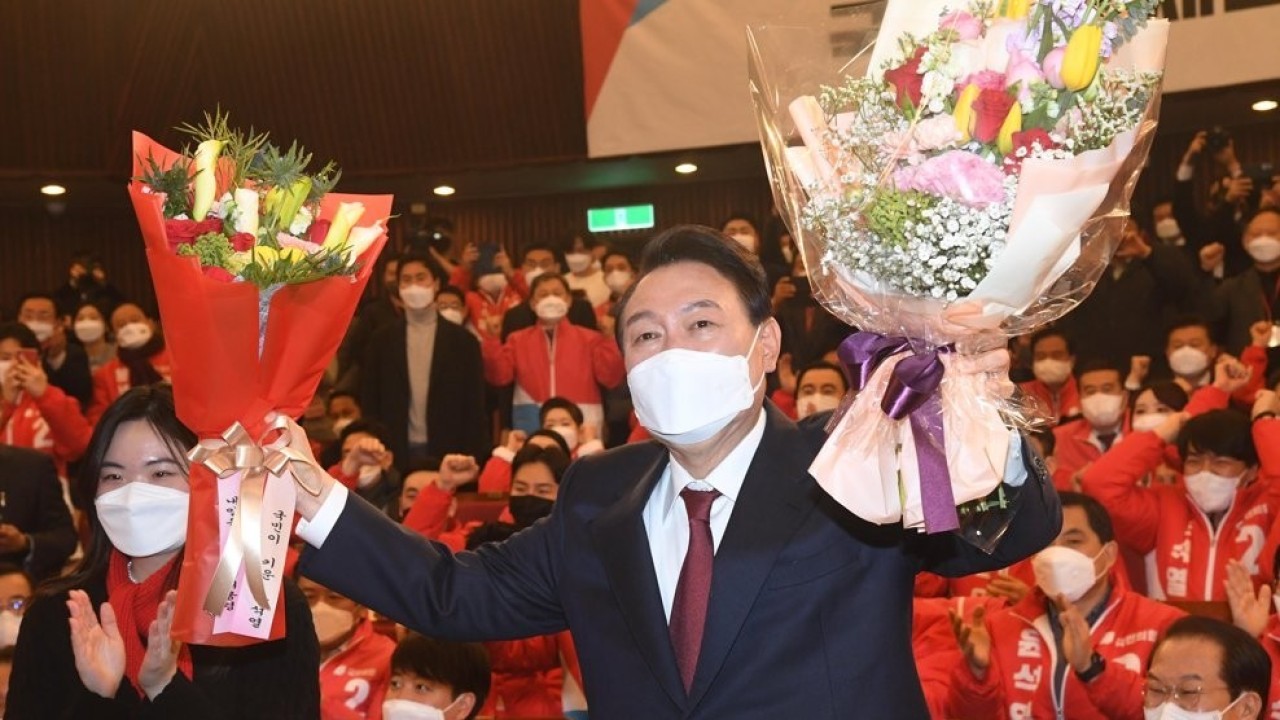 Presiden terpilih Yoon Suk-yeol berpose setelah menerima bunga di ruang situasi pemilihan partainya di Majelis Nasional di Seoul pada 10 Maret 2022. (Yonhap)