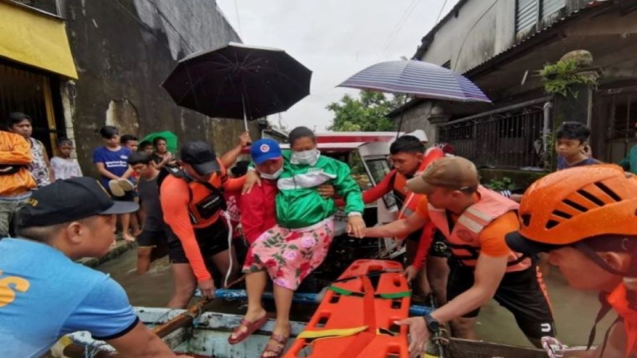 Petugas penyelamat membantu seorang wanita naik ke rakit di tengah banjir menyusul badai tropis Megi. (Filippine Coast Guard/Handout via Reuters)