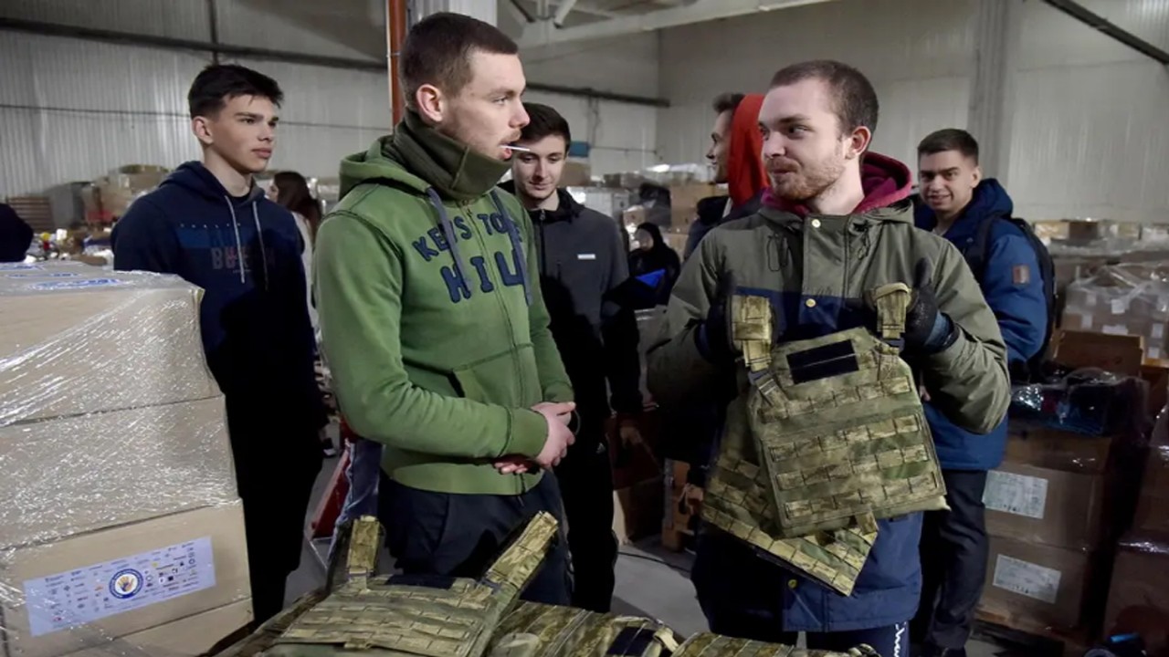 Seorang pria memamerkan rompi anti peluru sumbangan untuk tentara Ukraina hadapi pasukan Rusia. (Reuters)