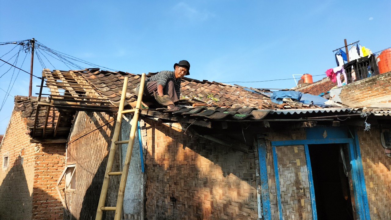 Warga sedang memperbaiki atap rumah yang ambruk pasca diterjang angin puting beliung, Jumat, (20/5). Foto: Saifal Ode