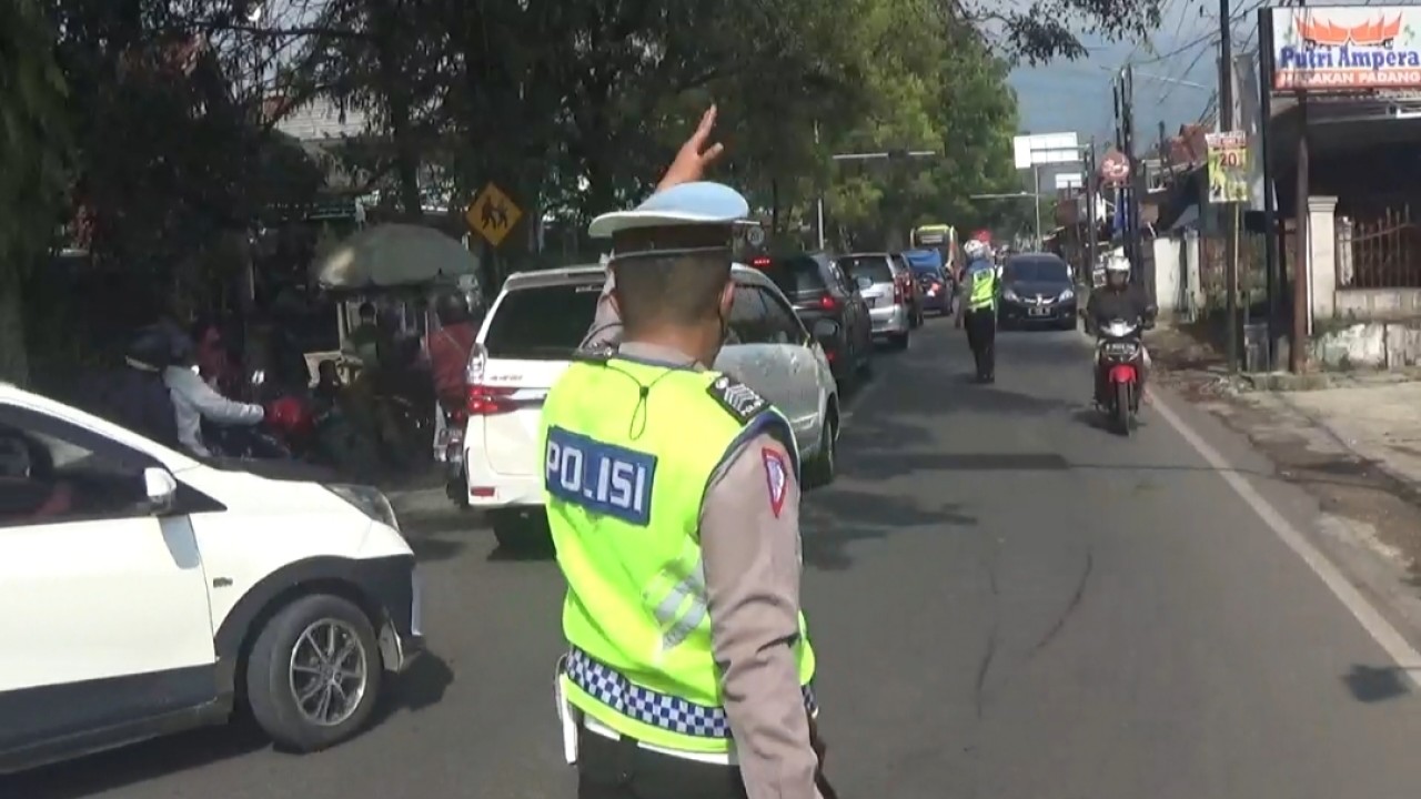Petugas kepolisian dari Polreta Bandung melakukan rekayasa lalu lintas. Foto: Saifal Ode