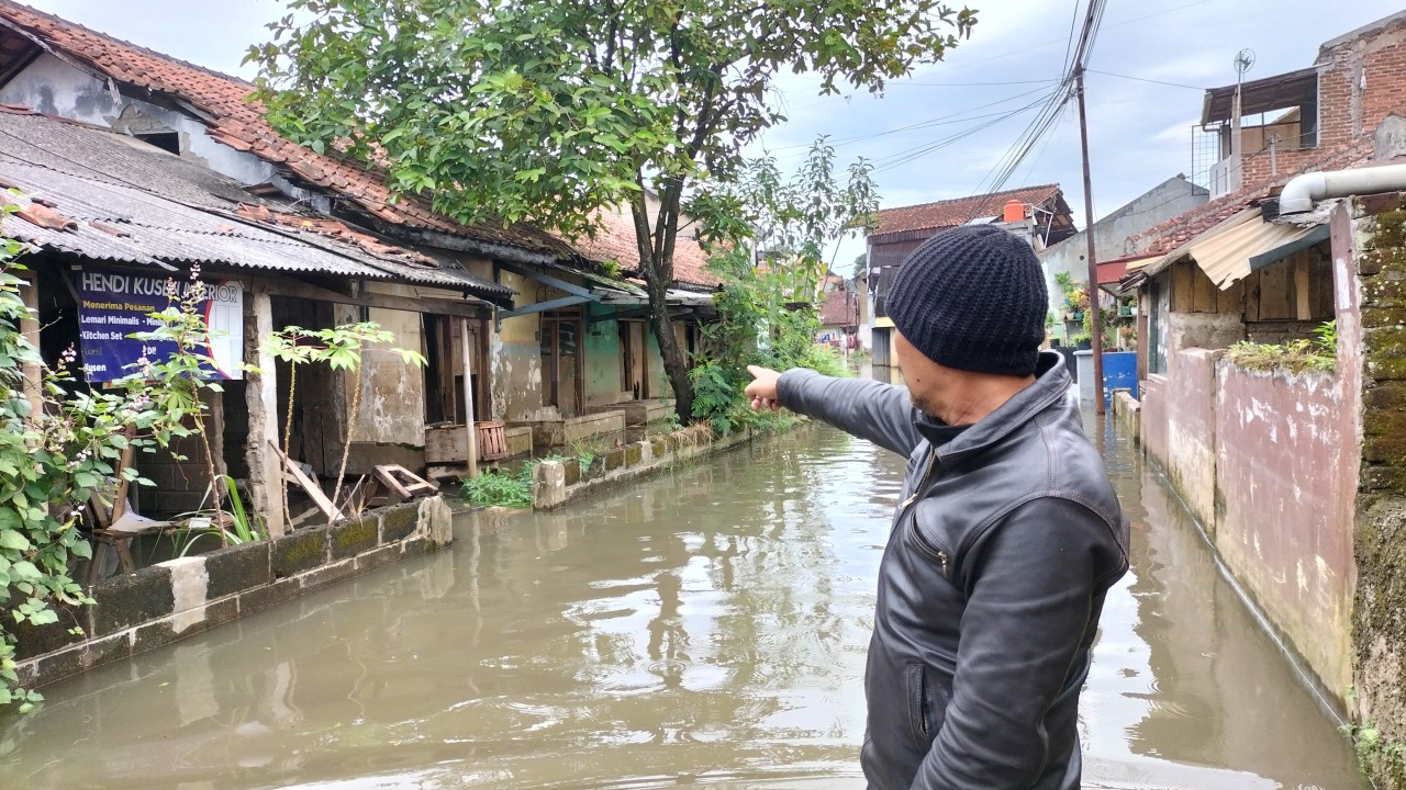 Warga menunjuk rumah tanpa penghuni di daerah banjir di desa Citeureup Bandung