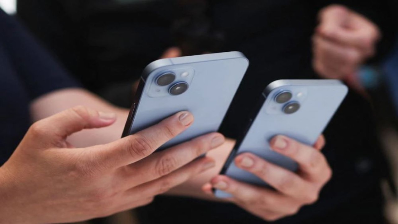 Seorang pengunjung memegang iPhone 14 baru di acara Apple di kantor pusat mereka di Cupertino, California, Amerika Serikat, pada 7 September 2022. (Carlos Barria/Reuters)