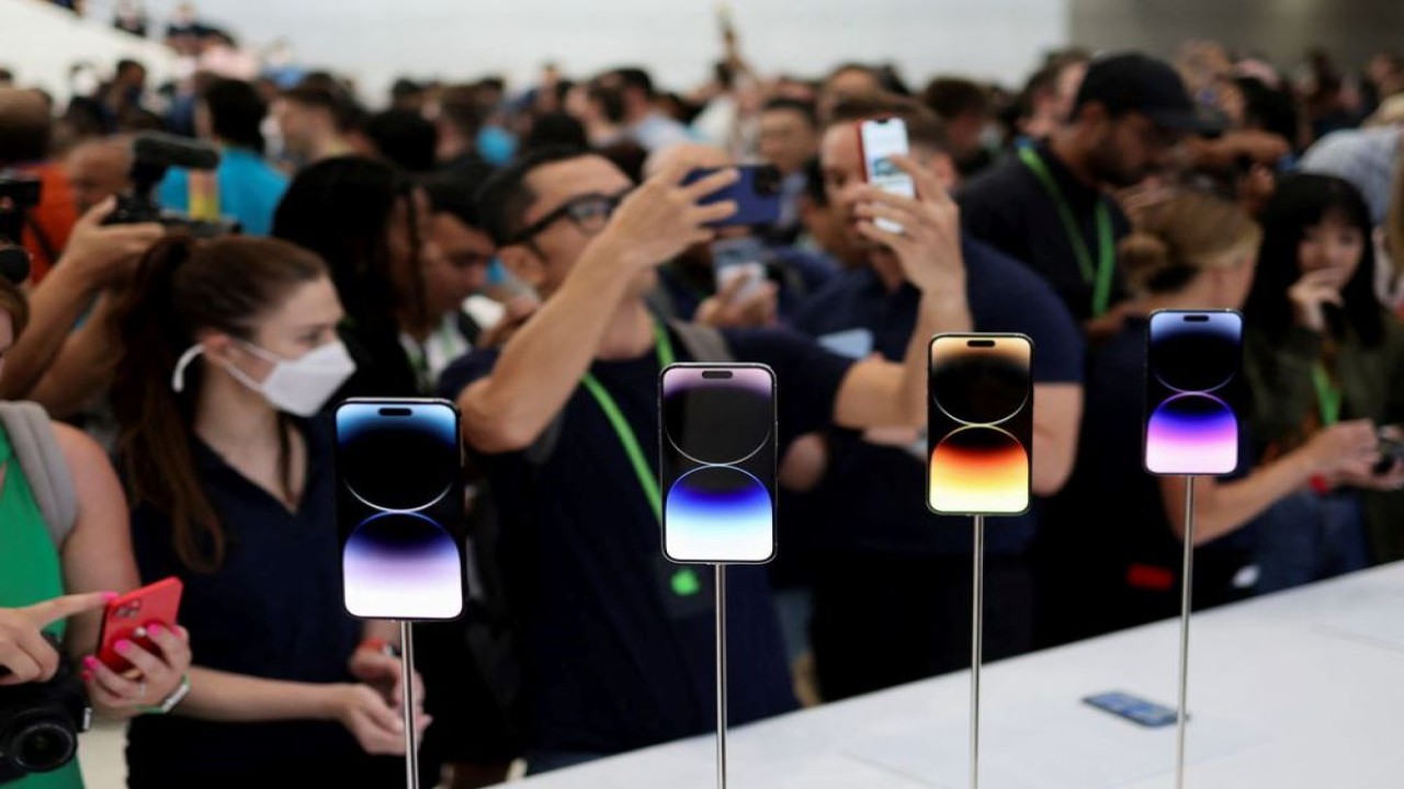 Seorang pengunjung melihat iPhone 14 baru di acara Apple di kantor pusat mereka di Cupertino, California, AS, pada 7 September 2022. (Carlos Barria/Reuters)