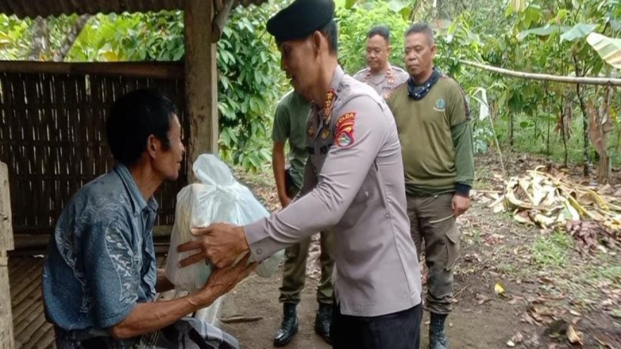 Personil Polda NTB memberikan paket sembako kepada warga kurang mampu yang tinggal di di Kawasan Taman Hutan Raya Nuraksa, Dusun Kumbi, Desa Pakuan, Kecamatan Narmada, Kabupaten Lombok Barat pada Selasa (20/9/2022). Foto (Istimewa)