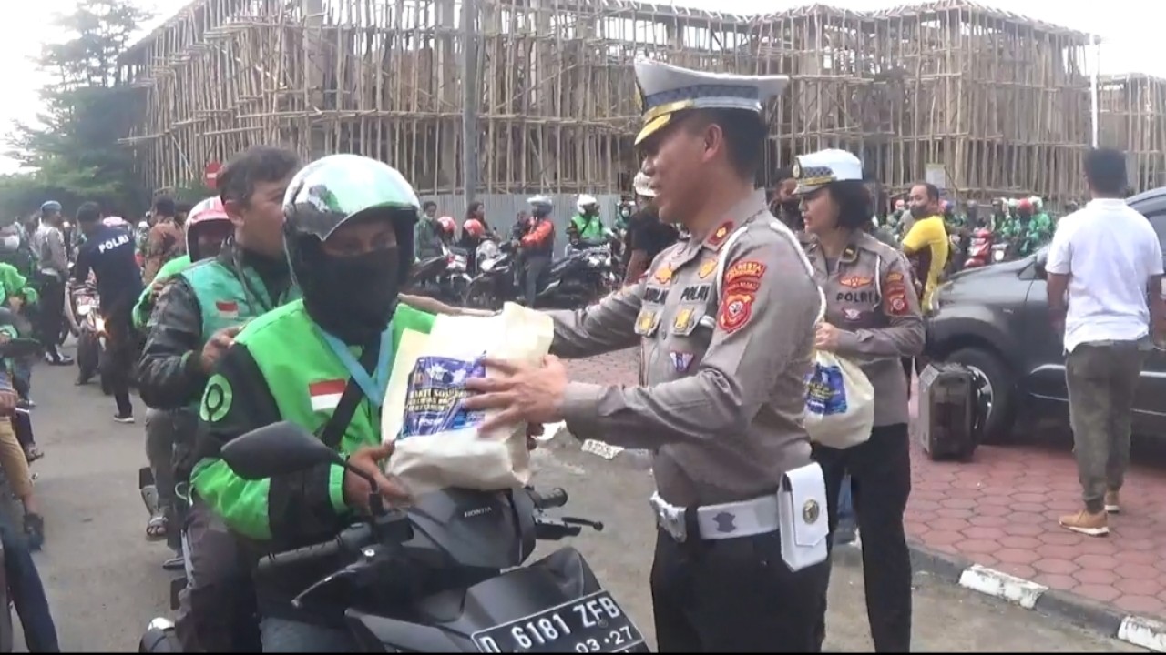 Kasatlantas Polresta Bandung memberikan Bansos kepada dirver Ojol.