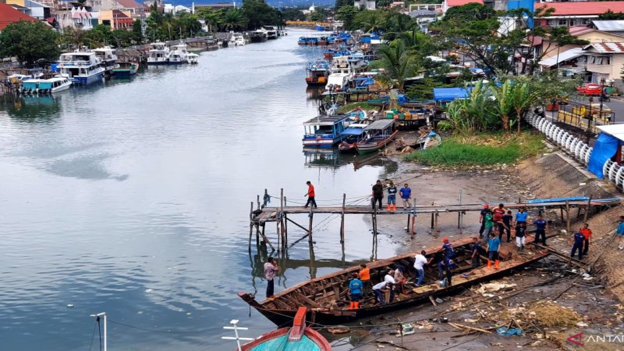 Petugas membersihkan bangkai kapal di Sungai Batang Arau Padang, Kamis (13/10/2022). ANTARA/Ikhwan Wahyudi