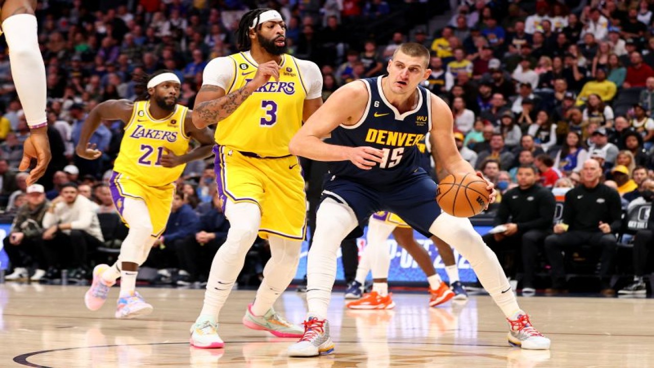 Pebasket Denver Nuggets Nikola Jokic (kanan) mendribel bola melewati pemain Los Angeles Lakers Anthony Davis saat pertandingan NBA di Ball Arena Denver, Colorado, pada 26 Oktober 2022 (Getty Images via AFP/JAMIE SCHWABEROW)