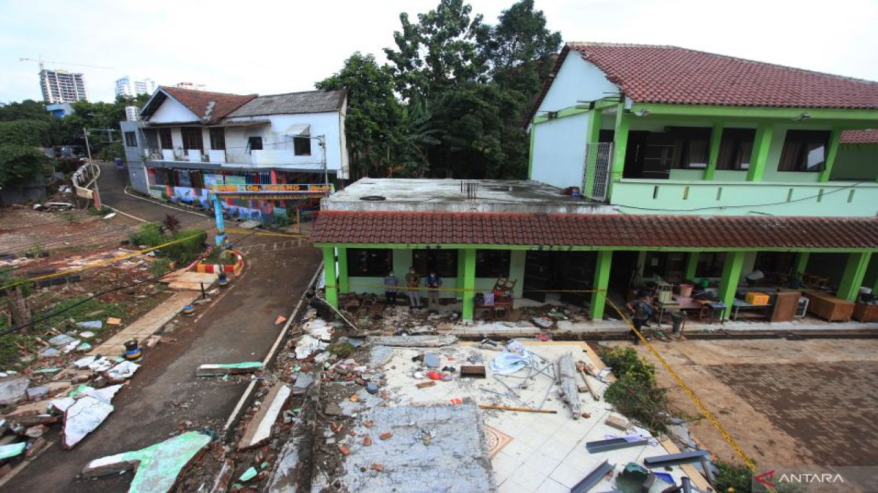 Sejumlah petugas mengamati tembok roboh akibat banjir di MTSN 19 Pondok Labu, Jakarta, Jumat (7/10/2022). ANTARA FOTO/Reno Esnir/hp.