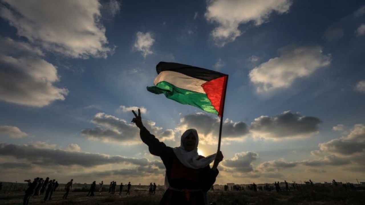 Ilustrasi. Seorang warga mengibarkan bendera Palestina. (Net)