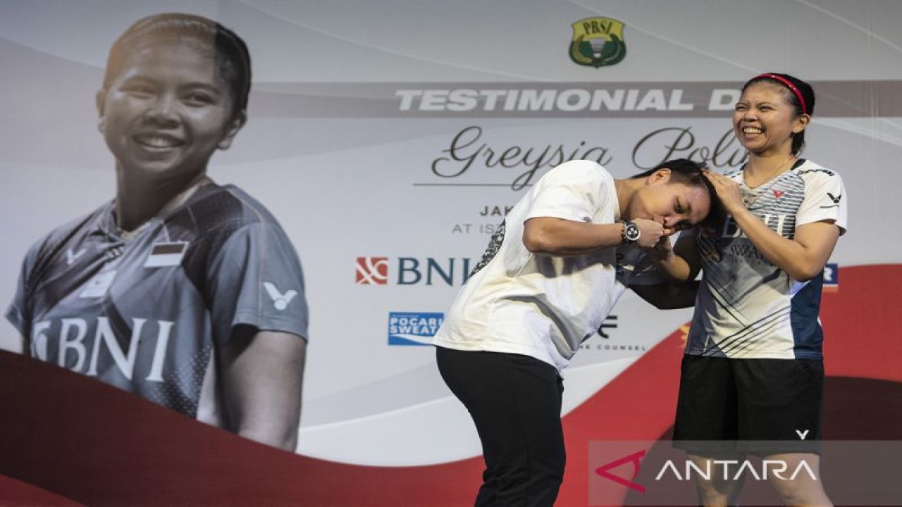 Pebulu tangkis ganda putri Indonesia Apriyani Rahayu (kiri) mencium tangan mantan pasangan bulu tangkis ganda putrinya Greysia Polii (kanan) pada acara "Testimonial Day Greysia Polii" di Istora Senayan, Jakarta, Minggu (12/6/2022). Dalam acara tersebut Greysia Polii yang juga peraih medali emas Olimpiade Tokyo 2020 itu, secara resmi mengumumkan pensiun sebagai atlet bulu tangkis profesional. ANTARA/Muhammad Adimaja/YU