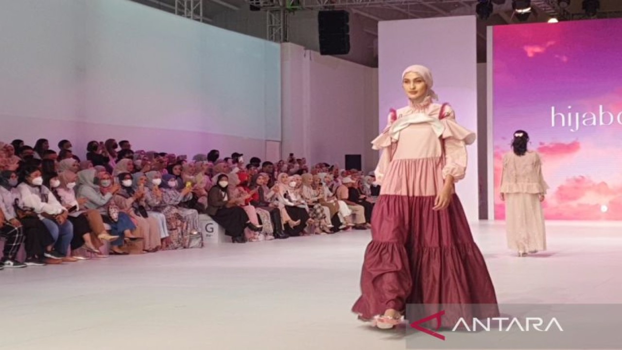 Penampilan model yang menggunakan balutan koleksi "Opera Pink" karya HijabChic dalam penampilan fesyen bertajuk "Woman In Rhytm" di Jakarta Fashion Week 2023, Sabtu (29/10/2022). (ANTARA/Livia Kristianti)