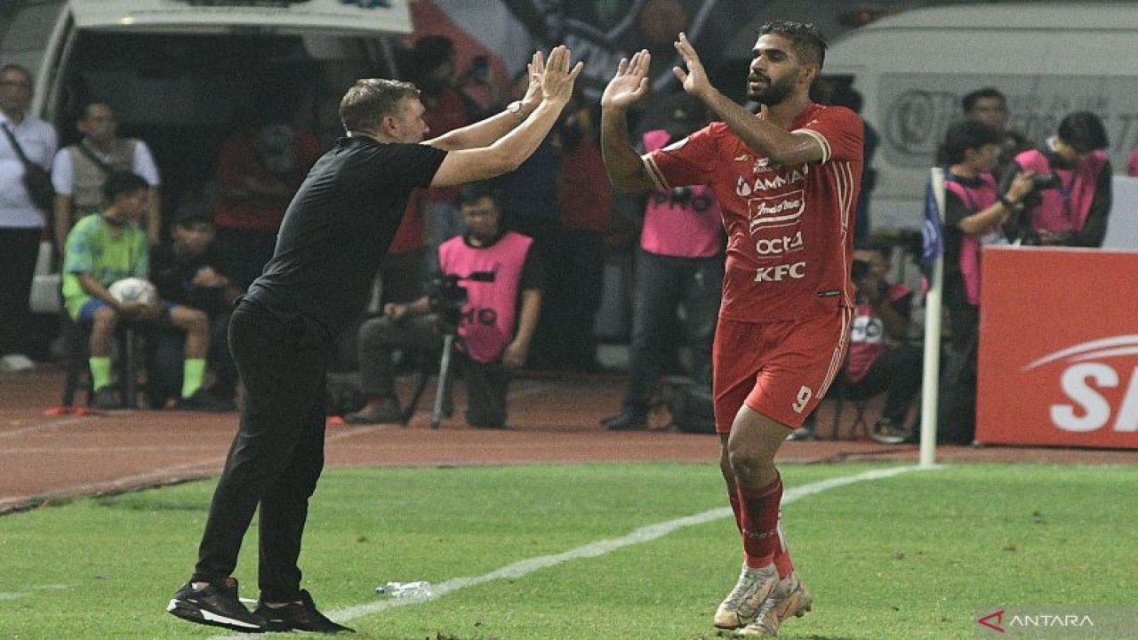 Pesepak bola Persija Jakarta Abdulla Yusuf (kanan) melakukan selebrasi bersama Pelatih Thomas Doll (kiri) usai menjebol gawang Persita Tangerang.  (ANTARA FOTO/Fakhri Hermansyah)