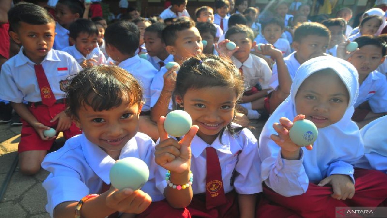 Sejumlah siswa menunjukkan telur bebek saat kegiatan Gerakan Gemar Makan Telur di Sekolah Dasar Negeri (SDN) 3 Bringin, Batealit, Jepara, Jawa Tengah, Selasa (30/8/2022). Gerakan makan telur yang diikuti seluruh siswa tersebut untuk pemenuhan gizi protein hewani untuk anak agar terhindar dari masalah stunting atau gagal tumbuh pada anak agar menghasilkan generasi yang lebih unggul. ANTARA FOTO/Yusuf Nugroho/aww. (ANTARA FOTO/YUSUF NUGROHO)