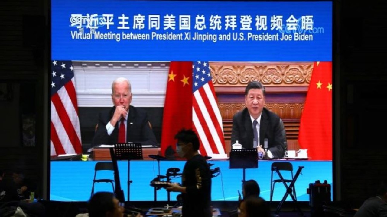 Sebuah layar menunjukkan Presiden China Xi Jinping menghadiri pertemuan virtual dengan Presiden AS Joe Biden melalui tautan video pada November 2021. (Tingshu Wang/Reuters)