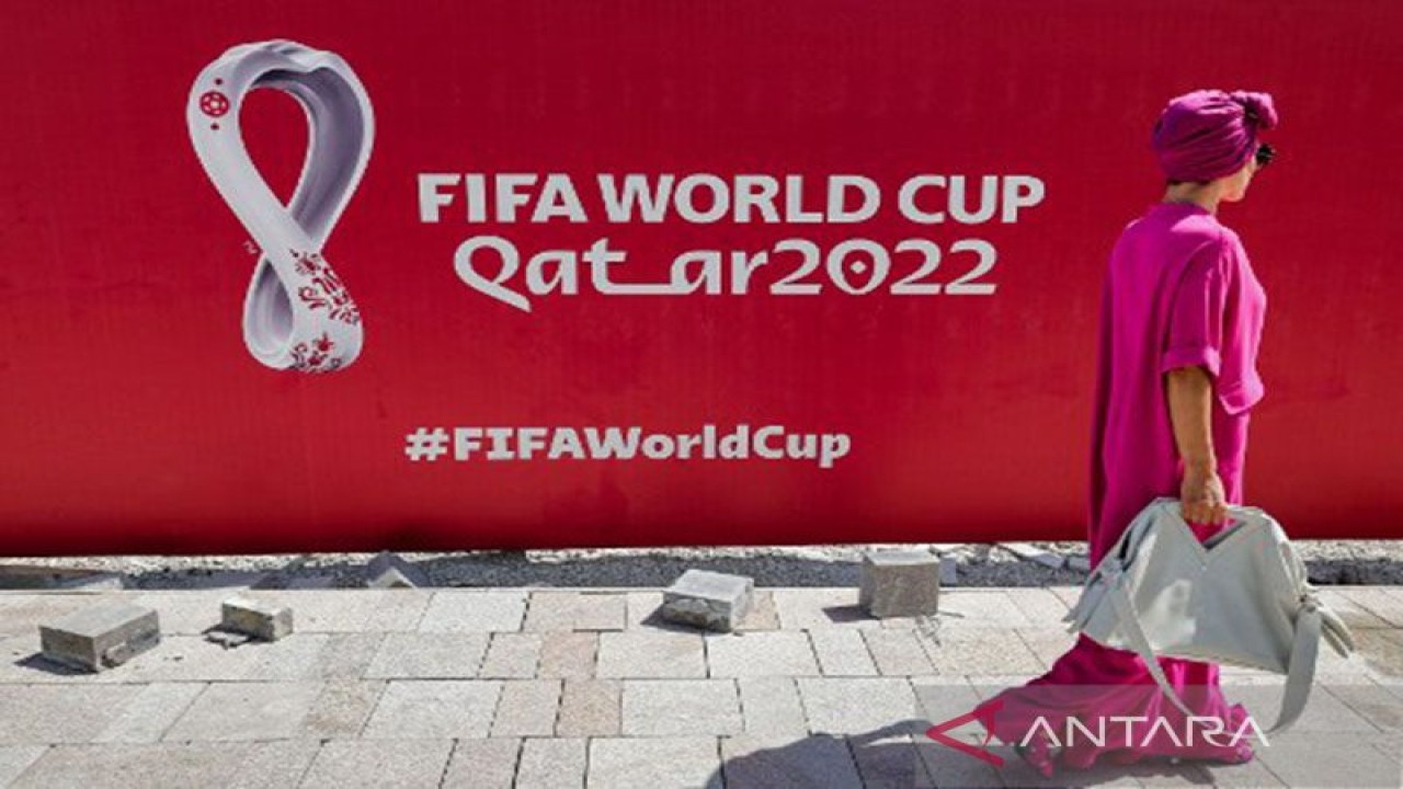 Arsip foto - Seorang wanita berjalan di depan baliho besar logo Piala Dunia FIFA 2022 di West Bay Doha, Qatar, pada 13 Oktober 2022. ANTARA/AFP/Giuseppe Cacace/pri. (AFP/GIUSEPPE CACACE)