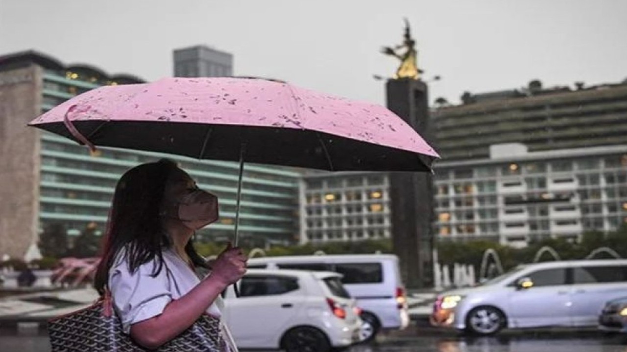 Arsip foto - Seorang warga menggunakan payung saat turun hujan di kawasan Bundaran Hotel Indonesia, Jakarta, Selasa (4/10/2022). (ANTARA FOTO/M Risyal Hidayat/tom/pri)