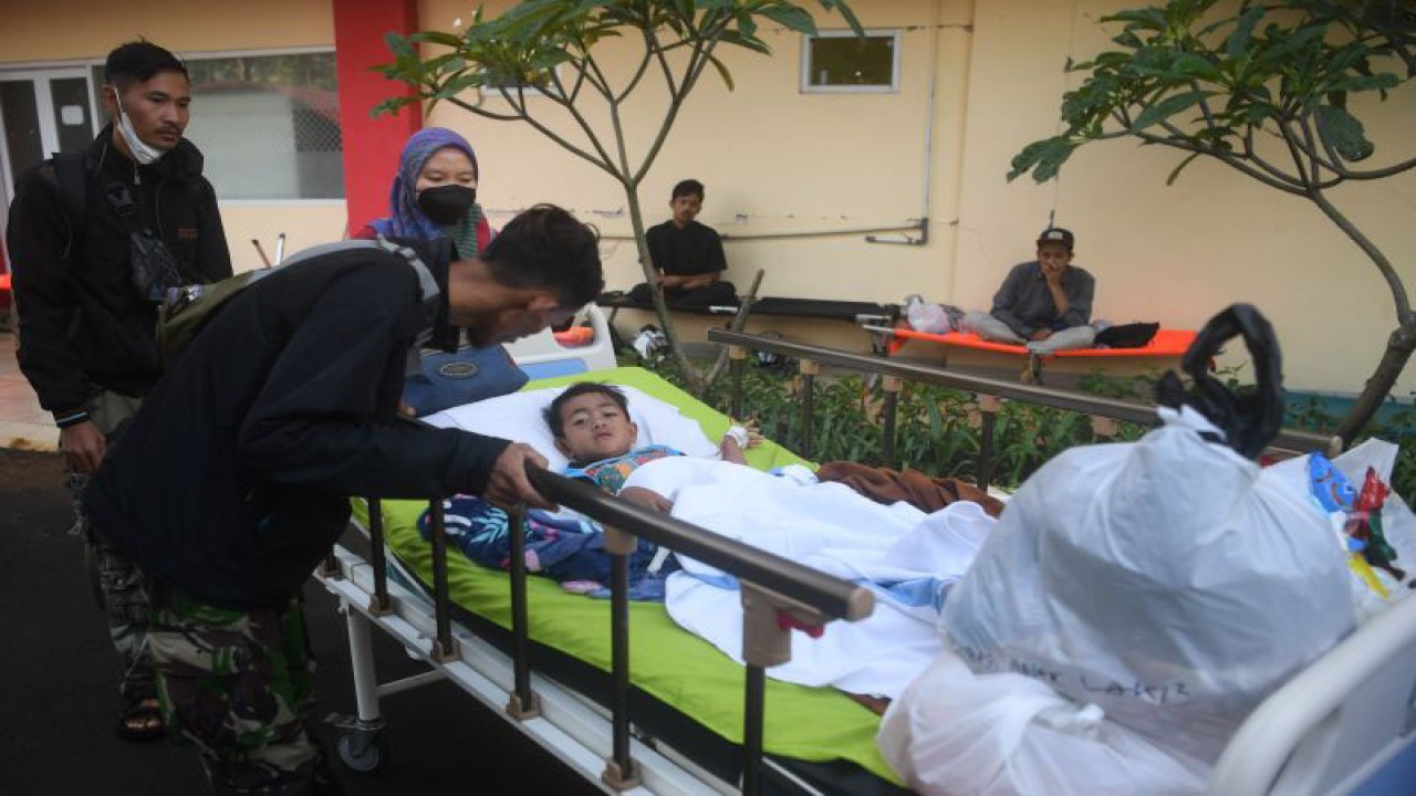 Keluarga memindahkan Azka (6), korban selamat setelah dua hari tertimpa reruntuhan akibat gempa bumi magnitudo 5,6 saat dirawat di RSUD Sayang, Kabupaten Cianjur, Jawa Barat, Kamis (24/11/2022). . ANTARA FOTO/Wahyu Putro A/rwa. (ANTARA FOTO/WAHYU PUTRO A)