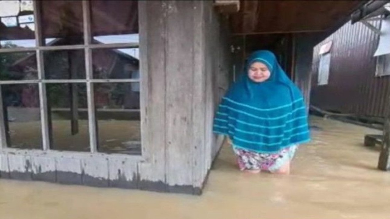 Seorang ibu korban banjir di HSU belum mengungsi meski sebagian besar lantai rumahnya sudah terendam banjir, Sabtu (19/11/22) (ANTARA/Eddy A/Diskominfo HSU)