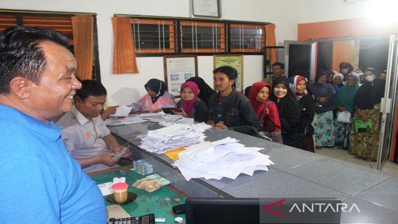 Penyaluran bantuan sosial dari Kemensos RI di Kantor Pos Biaro, Agam, Sumatera Barat dilakukan hingga malam hari. ANTARA/dokumentasi