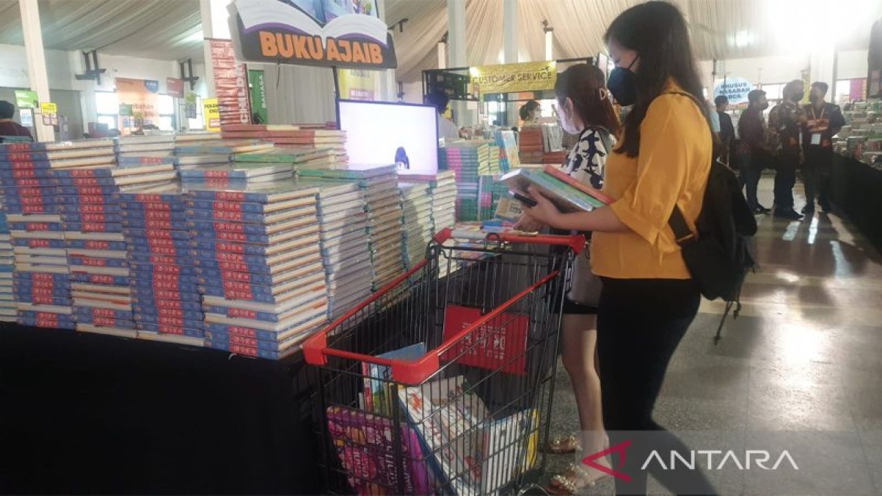 Seorang pengunjung tengah memilih buku sebelum dimasukkan dalam troli pada Bazar buku Big Bad Wolf Books (BWB) Semarang yang berlangsung mulai tanggal 28 Oktober sampai 6 November 2022. Bazar bertempat di PRPP Gedung Sumbing, selama 15 jam tepat pukul 09:00 sampai dengan 23:00 WIB.  (ANTARA/Nur Istibsaroh)