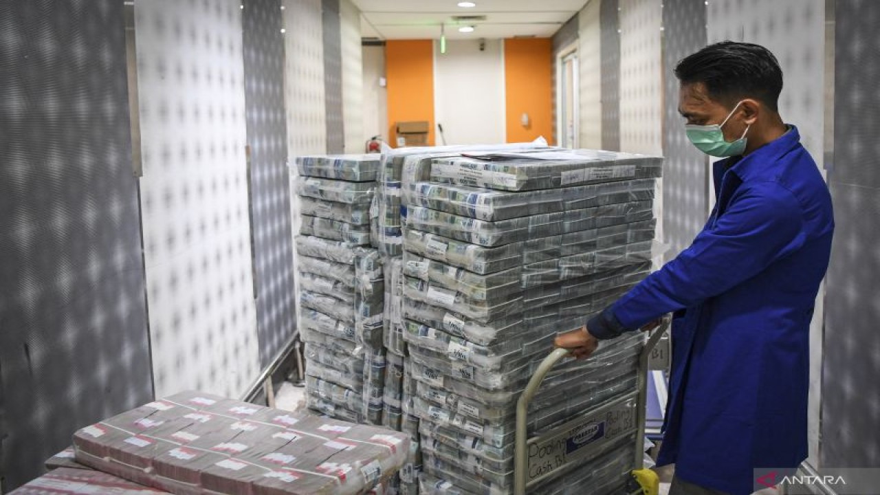 Petugas menarik tumpukan uang tunai sebelum didistribusikan melalui kantor cabang dan mesin ATM di Pooling Cash Plaza Mandiri, Jakarta, Kamis (8/9/2022). ANTARA FOTO/M Risyal Hidayat/foc.