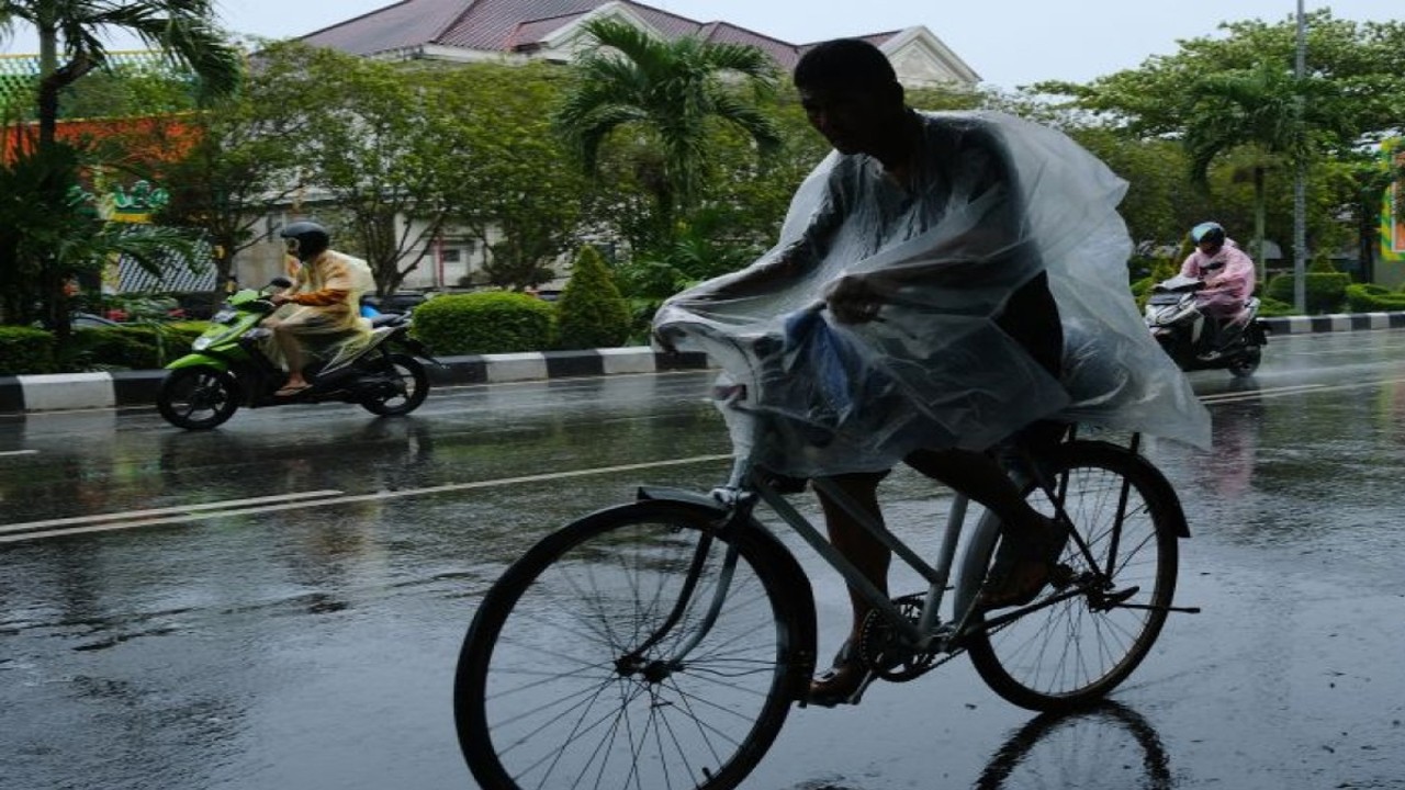 Seorang pengendara sepeda melintas saat hujan di Pontianak, Kalimantan Barat, Senin (21/11/2022). BMKG Kalbar memprakirakan terdapat potensi hujan intensitas sedang-lebat yang dapat disertai petir/angin kencang berdurasi singkat, khususnya pada kejadian hujan siang/sore dan malam hari di sebagian besar wilayah Kalimantan Barat pada 21 November dan 23-26 November 2022. ANTARA FOTO/Jessica Helena Wuysang/tom. (ANTARA FOTO/JESSICA HELENA WUYSANG)