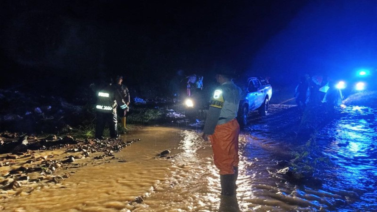 BPBD Kabupaten Manggarai Barat bersama Polres Manggarai Barat bekerja sama mengatasi material banjir yang menghalangi Jalan Trans Flores, Wae Lus, Culu, Desa Tondong Belang, Kecamatan Mbeliling, NTT, Sabtu (19/11/2022) malam. (ANTARA/Fransiska Mariana Nuka)