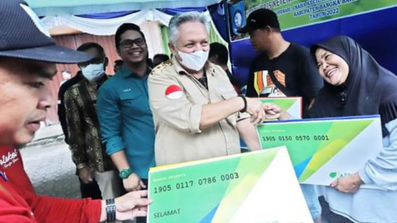 Bupati Bangka Barat Sukirman (masker putih) secara simbolis menyerahkan kartu BPJS Ketenagakerjaan kepada perwakilan pedagang di Pasar Mentok. ANTARA/HO-Diskominfo Bangka Barat