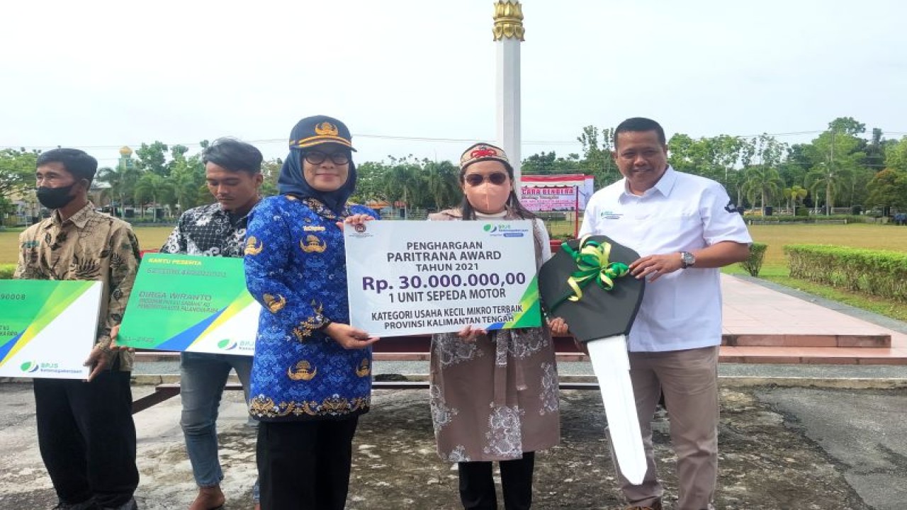 Kepala BPJS Ketenagakerjaan (BPJSMSOSTEK) Cabang Palangka Raya, Budi Wahyudi (kanan) dan Sekda Kota Palangka Raya Hera Nugrahayu (kiri) menerahkan simbolis hadiah uang pembinaan dan satu sepeda motor bagi UKM Indang Apang Galeri sebagai juara kedua nasional program Paritrana Awards di Palangka Raya, Selasa (29/11/2022). (ANTARA/Rendhik Andika)