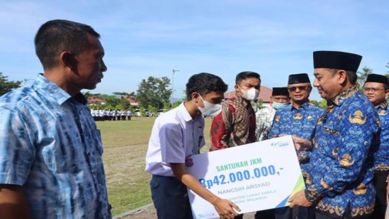 Bupati Bone Bolango Hamim Pou (kedua kanan) menyerahkan Jaminan Kematian (JKM) dari BPJAMSOSTEK Cabang Gorontalo kepada tiga ahli waris Korpri Bone Bolango yang meninggal di Alun-Alun Bone Bolango, Gorontalo. ANTARA/HO-Diskominfo Tulang Bolango