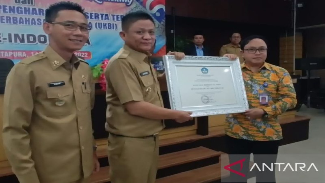 Bupati OKU Timur Lanosin Hamzah (tengah) menerima piagam penghargaan Uji Kemahiran Berbahasa Indonesia sebagai peserta paling banyak nasional, dari Badan Pengembangan dan Pembinaan Bahasa Kemendikbudristek RI (ANTARA/HO-Balai Bahasa Sumsel)
