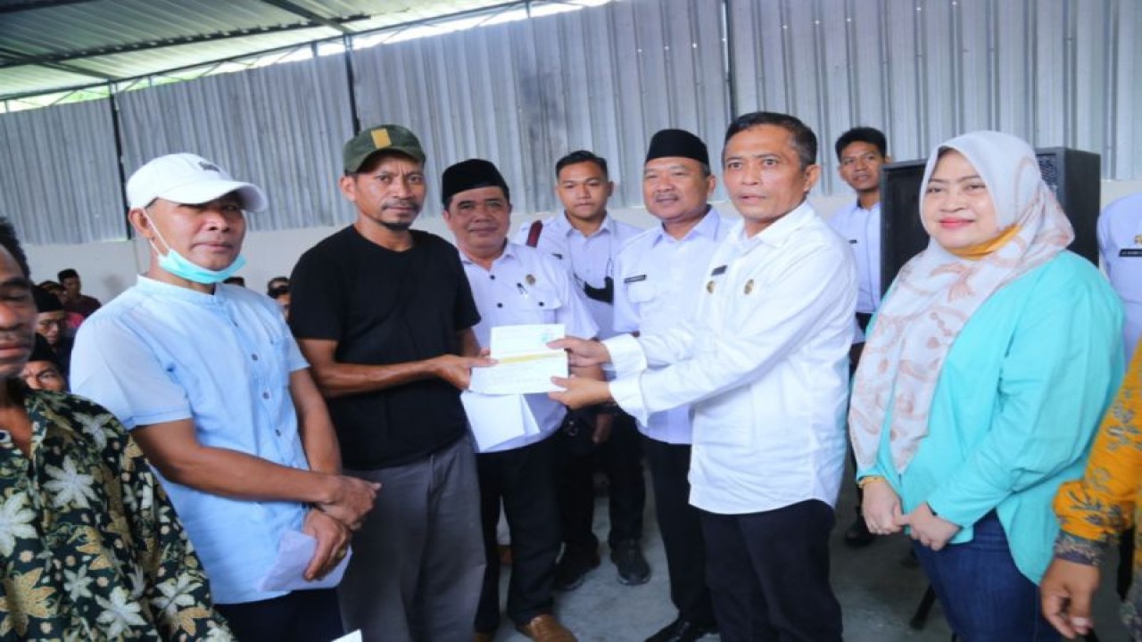 Bupati Lombok Tengah, Nusa Tenggara Barat, H Lalu Pathul Bahri (kanan kedua) saat menyerahkan buku rekening kepada KPM program BLT dari DBHCHT di Desa Ganti, Kecamatan Praya Timur, Rabu (23/11/2022). ANTARA/HO-Humas Pemkab Lombok Tengah