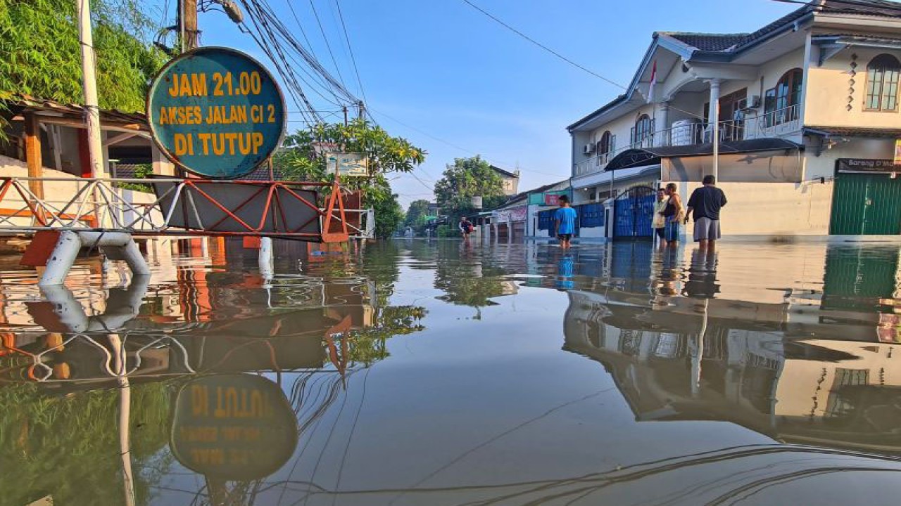 Sejumlah warga melintasi banjir yang merendam Perumahan Ciledug Indah, Ciledug, Tangerang, Banten, Minggu (11/9/2022). Banjir setinggi 50cm hingga 100cm yang merendam perumahan tersebut terjadi akibat meluapnya Kali Angke karena intensitas hujan yang cukup tinggi. ANTARA FOTO/Muhammad Iqbal/foc.  KOMENTAR