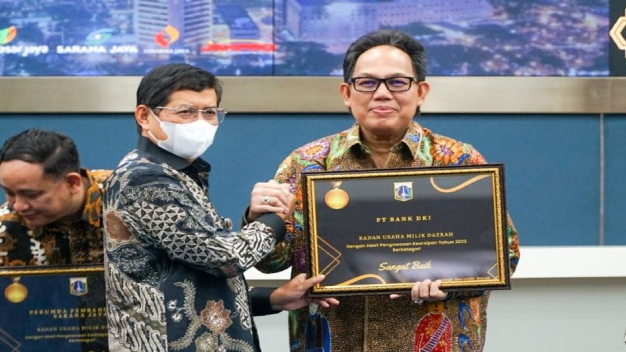 Direktur Utama Bank DKI Fidri Arnaldy (kanan) menerima piagam penghargaan sebagai BUMD Dengan Hasil Pengawasan Kearsipan Tahun 2022 berkategori sangat baik dari Sekretaris Daerah DKI Jakarta Marullah Matali (kiri) dalam acara Gerakan Sadar Tertib Arsip (GSTA) dan Pemberian Apresiasi Kearsipan Tahun 2022 DKI Jakarta pada Kamis (17/11/2022). ANTARA/HO-Bank DKI