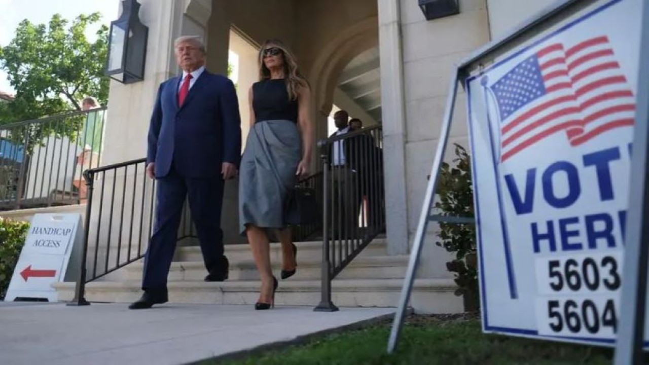 Mantan Presiden AS Donald Trump dan istrinya Melania berjalan di luar tempat pemungutan suara selama pemilihan paruh waktu di Palm Beach, Florida, AS, pada 8 November 2022. (Reuters)