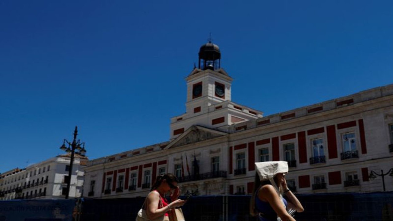 Ilustrasi seorang wanita menutupi kepalanya dengan tas saat berjalan di Alun-Alun Puerta del Sol pada hari yang panas saat Spanyol bersiap menghadapi gelombang panas di Madrid, Spanyol, 10 Juni 2022. ANTARA/REUTERS/Susana Vera/as.