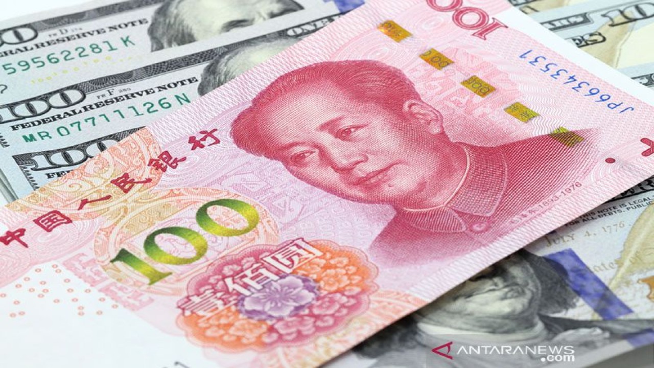 Ilustrasi - 100 yuan China di atas uang dolar AS. ANTARA/Shutterstock/pri.