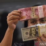 Ilustrasi - Pegawai menunjukkan mata uang rupiah dan dolar AS di salah satu gerai penukaran mata uang di Jakarta, ANTARA FOTO/Indrianto Eko Suwarso/YU/aa.-1668396836
