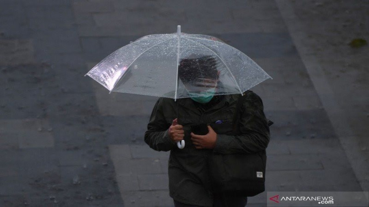 Ilustrasi - Seorang warga membawa payung saat melintas di Kawasan Senayan, Jakarta, Jumat (16/10/2020). (Dok ANTARA)