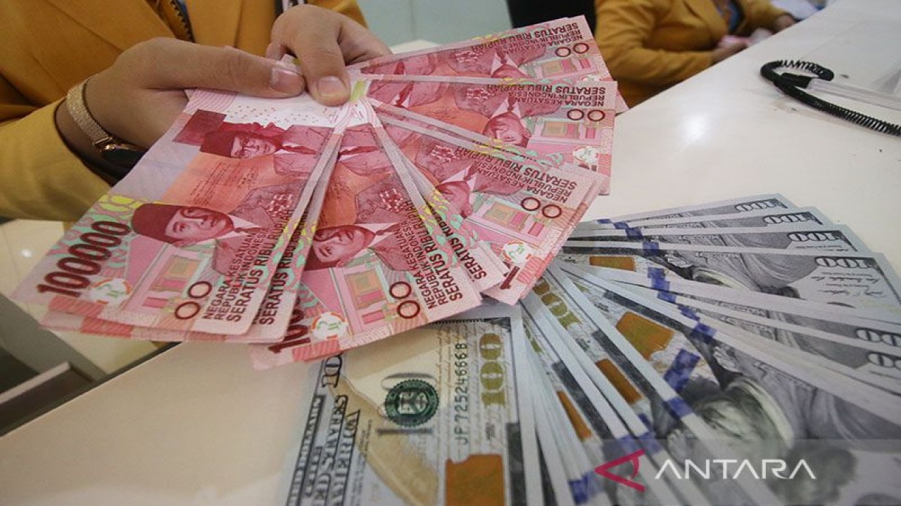 Ilustrasi: Teller sebuah bank menunjukkan uang pecahan dolar AS dan rupiah di Jakarta. ANTARA FOTO/Rivan Awal Lingga/ama.