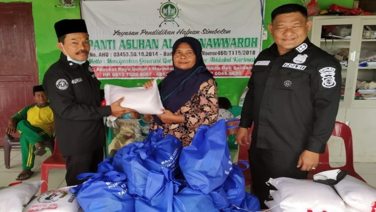 Kasubbid Penmas Polda Sumut AKBP Herwansyah Putra (kanan) memberikan sembako Panti Asuhan Al Munawwaroh Kabupaten Deli Serdang. (Foto:ANTARA/HO)