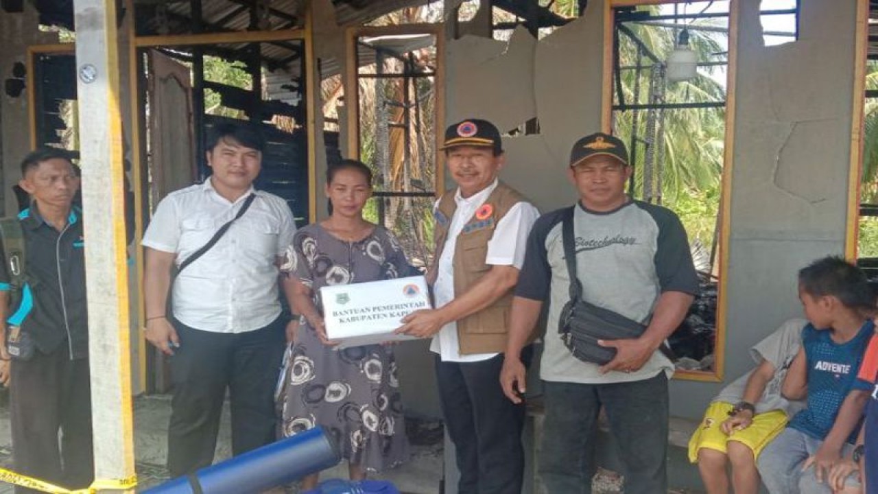 Kepala BPBD Kapuas Panahatan Sinaga menyerahkan bantuan untuk korban kebakaran di Desa Sei Teras, Kecamatan Kapuas Kuala, Rabu (9/11/2022). ANTARA/HO-BPBD Kapuas