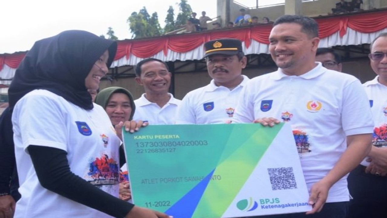 Kepala BPJS Ketenagakerjaan atau BPJAMSOSTEK Cabang Solok Maulana Anshari Siregar menyerahkan secara simbolis kartu kepesertaan program jaminan sosial ketenagakerjaan kepada perwakilan atlet Pekan Olahraga Kota Sawahlunto Tahun 2022. (ANTARA/Yudha Ahada)