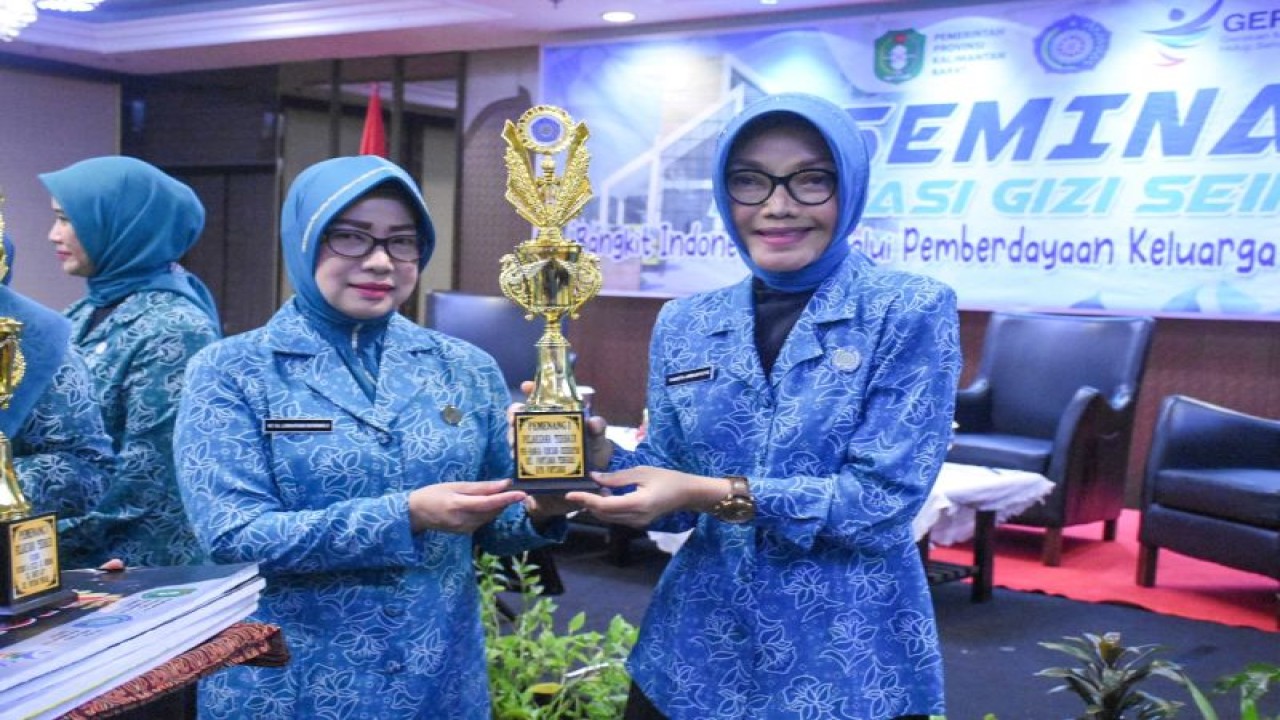 Ketua TP PKK Provinsi Kalbar Lismaryani menyerahkan piala dan piagam penghargaan (ANTARA/HO-Jimi)